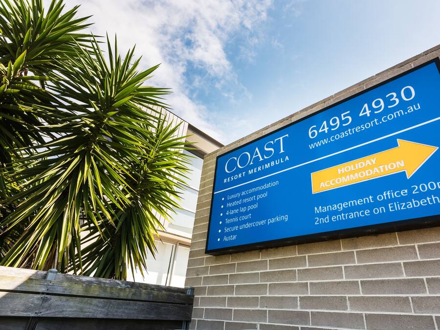 Señal para COAST Resort Merimbula con comodidades como alojamiento de lujo, piscina climatizada, cancha de tenis y estacionamiento seguro.