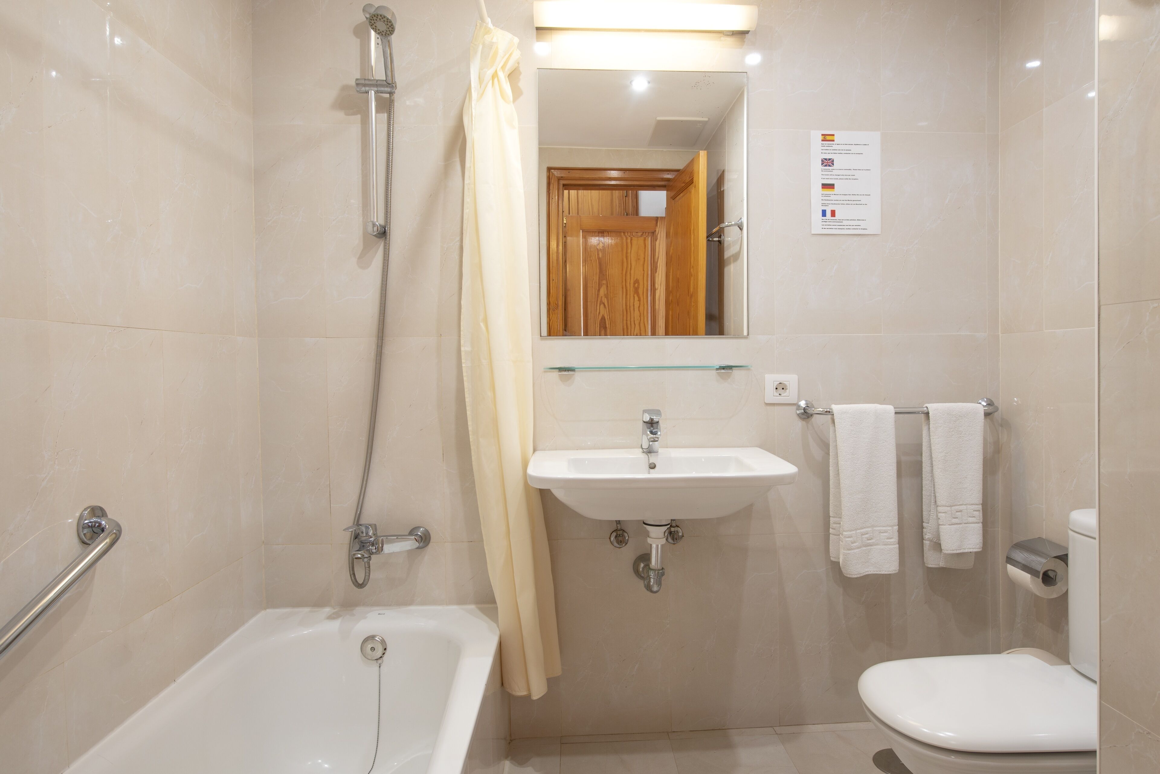 Un baño con bañera, lavamanos e inodoro.