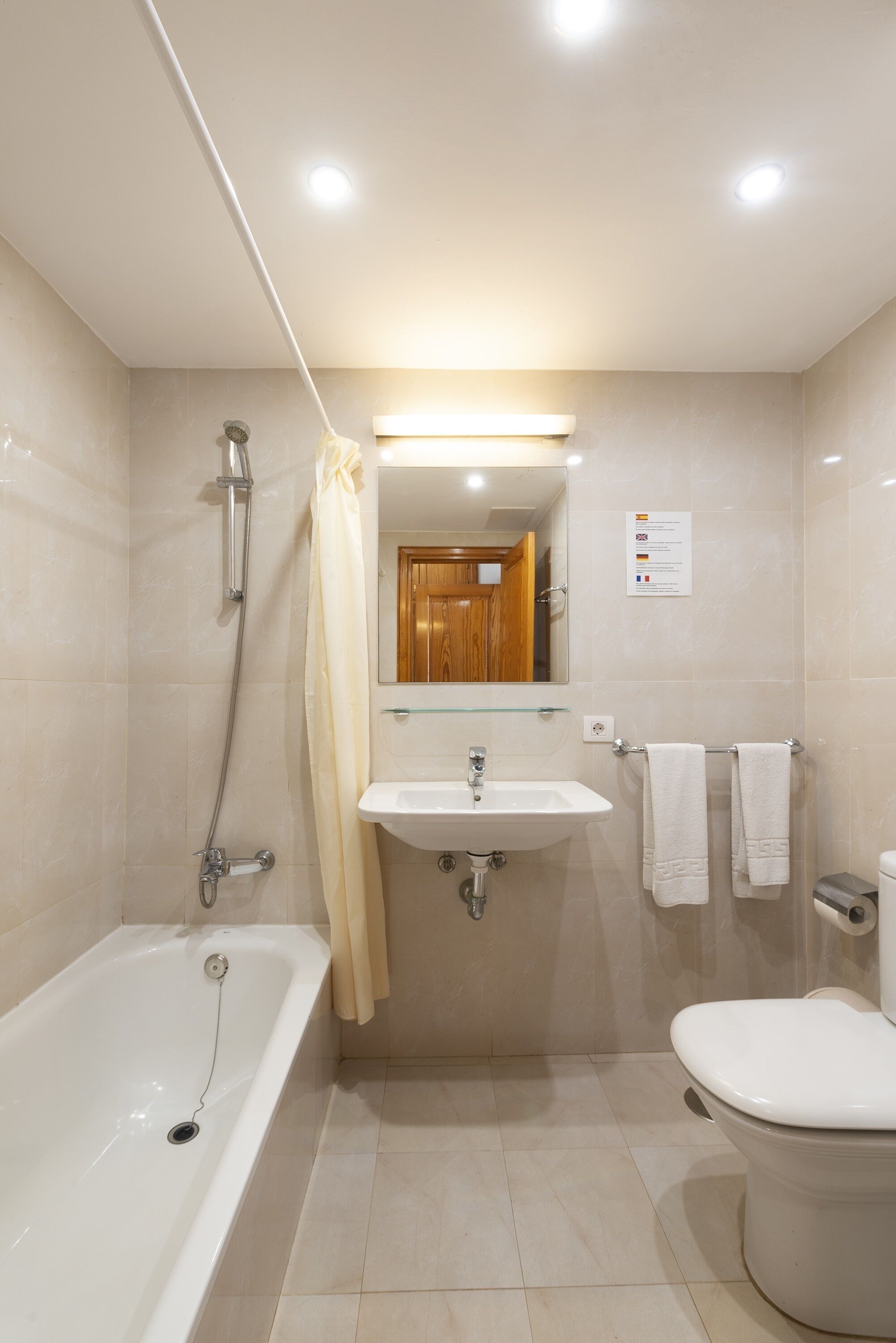 A modern bathroom with a bathtub, sink, and toilet.