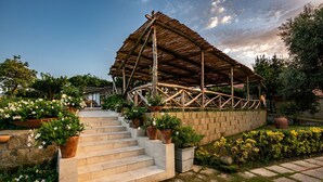 A covered outdoor area with a wooden structure, stone steps, and potted plants. - Sopramare Resort (Piano di Sorrento)