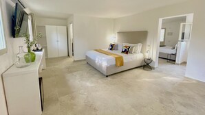 A spacious bedroom with a large bed, a bedside table, a mirror, and a wardrobe. - Sopramare Resort (Piano di Sorrento)