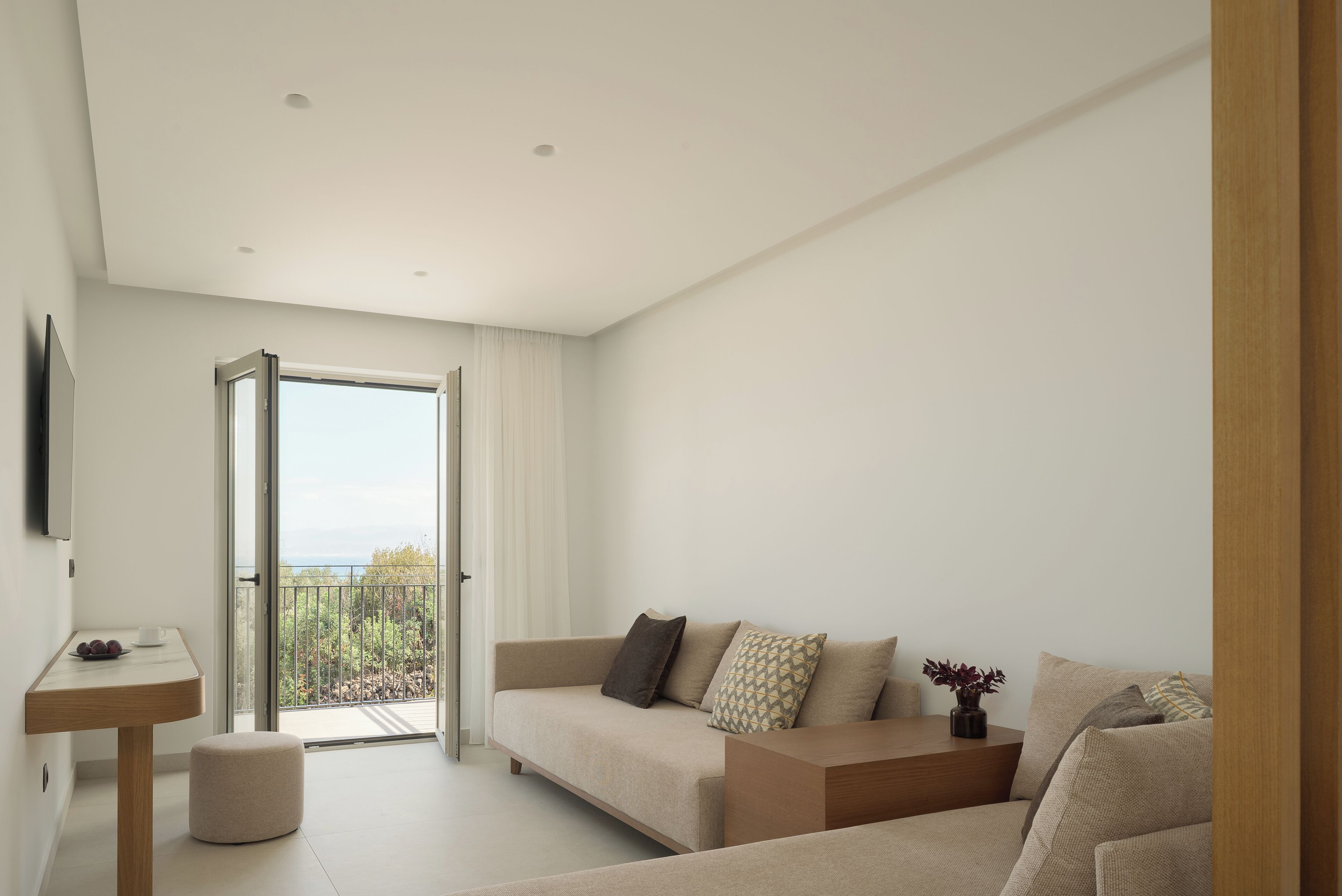 Una sala moderna con un sofá, una mesita y vistas a un balcón.