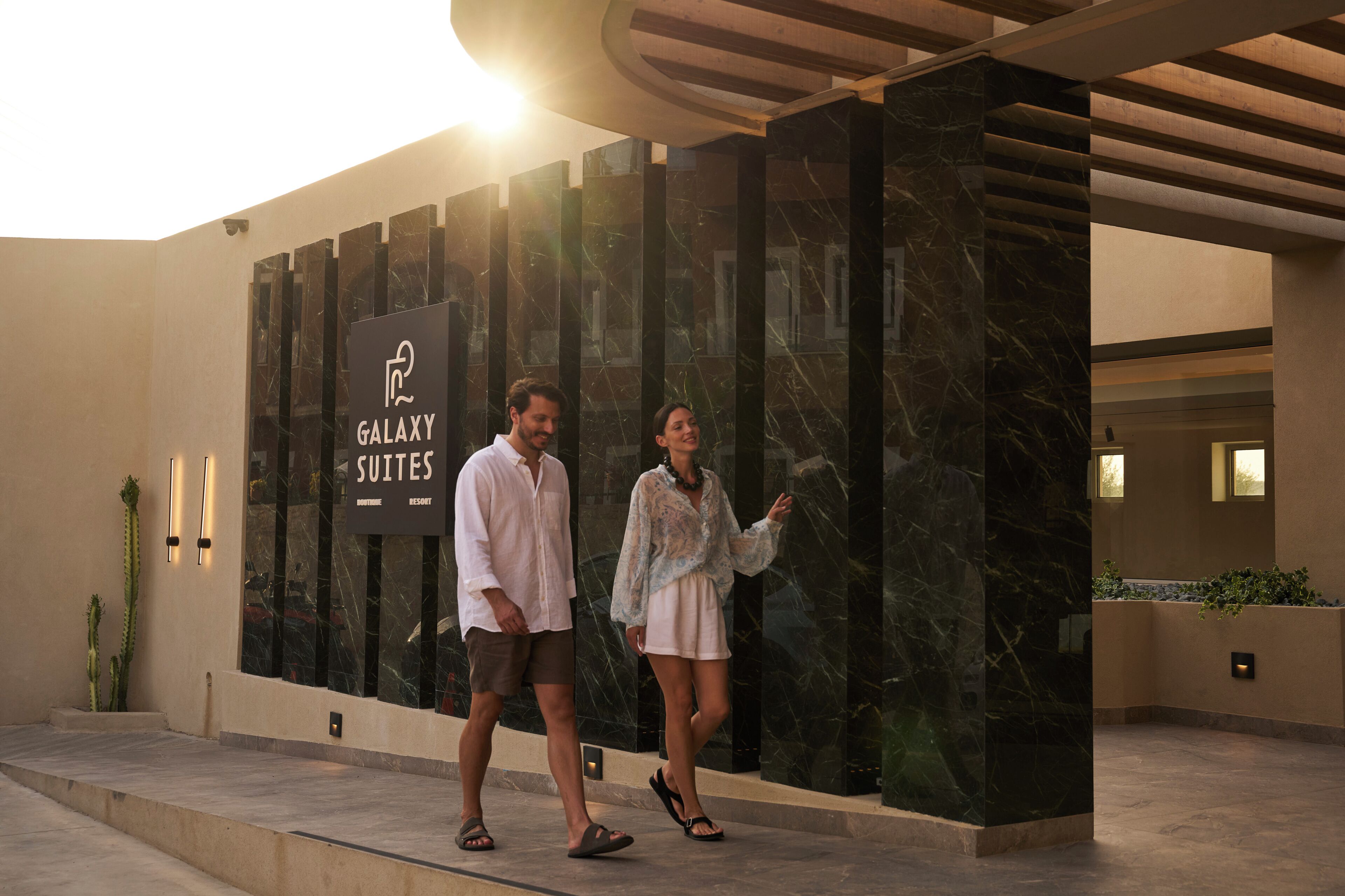 A hotel entrance with a sign for 'Galaxy Suites Boutique Resort'.