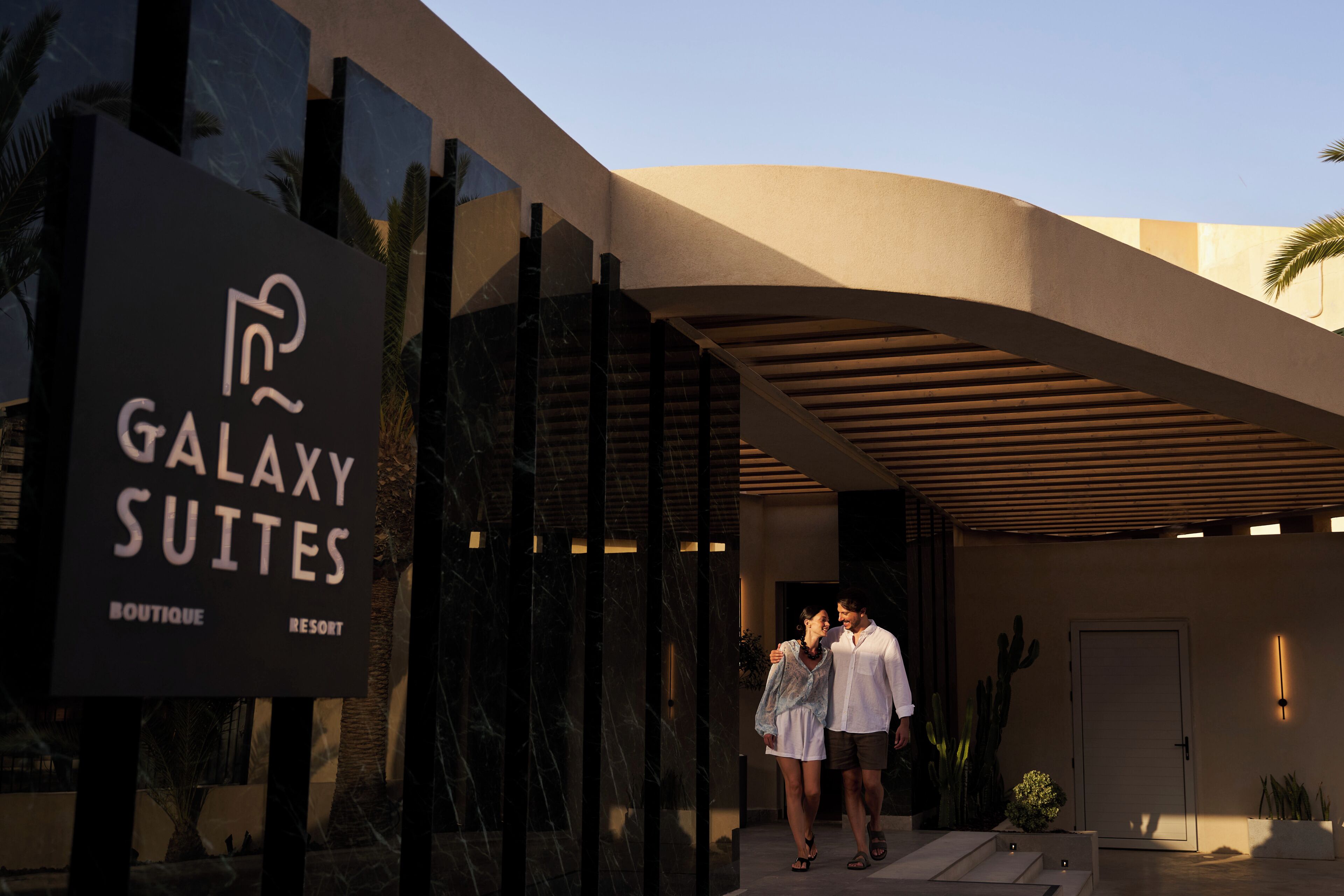 Un edificio moderno con un cartel que indica Galaxy Suites Boutique Resort.