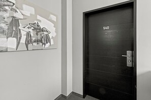 Uma porta preta com o número 540, uma maçaneta metálica e uma fechadura.