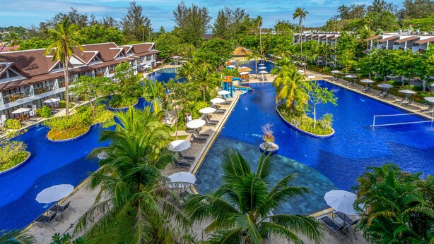 Een resort met meerdere zwembaden, palmbomen en terrasjes.