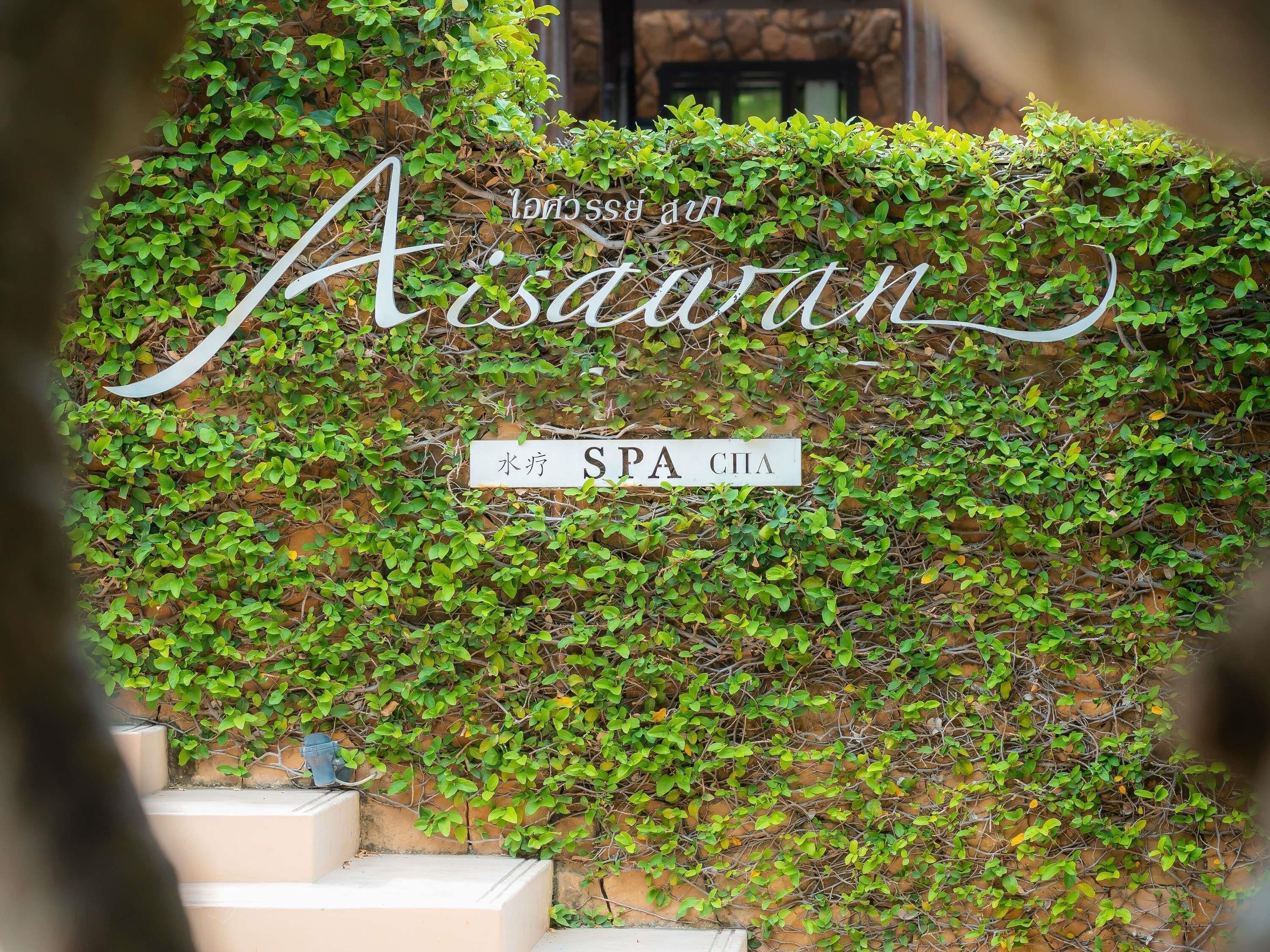 A wall with greenery and a sign indicating a spa.