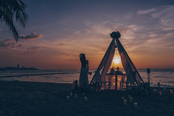Di pantai, kursi berjemur, handuk pantai, dan pijat di pantai