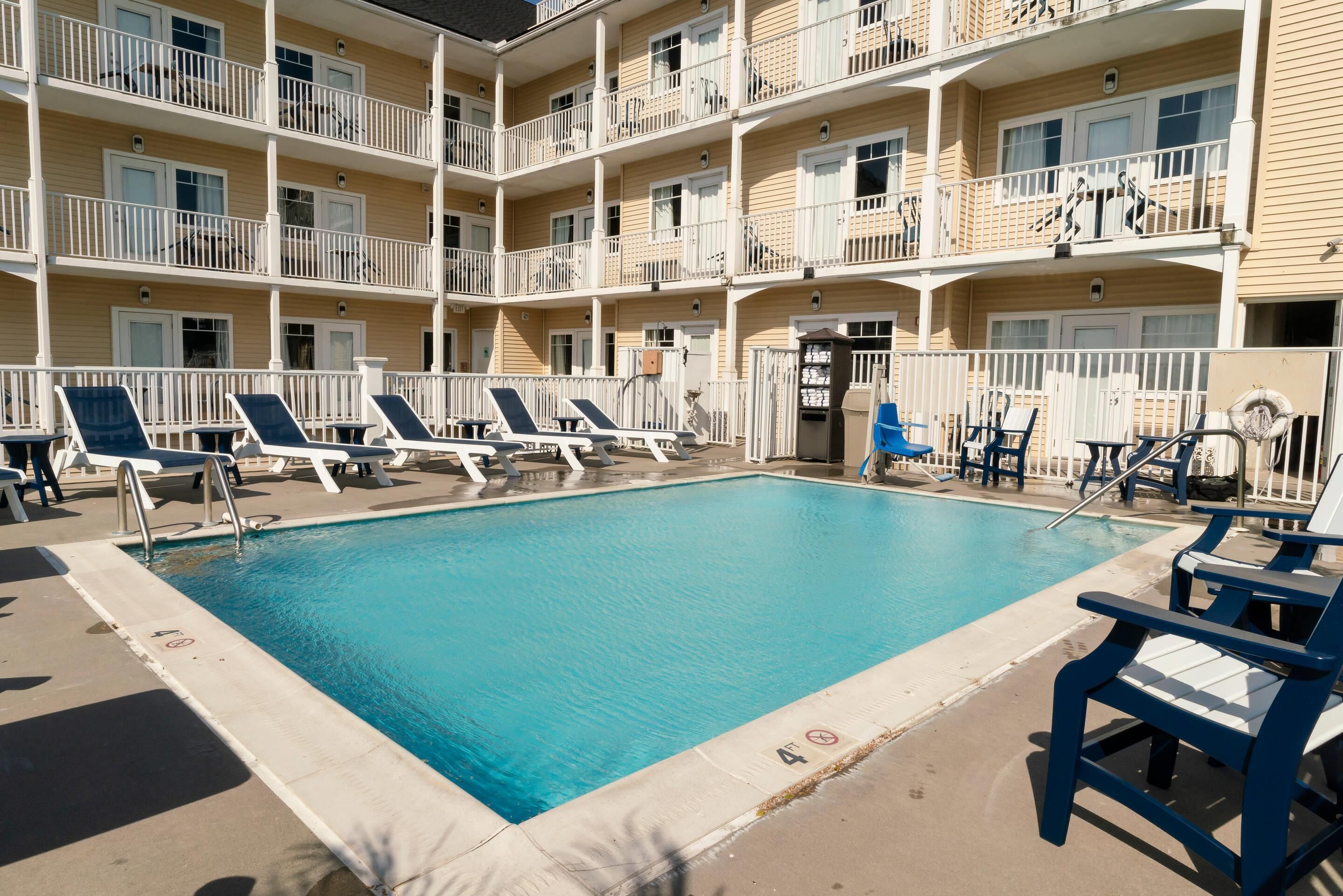 A pool area with lounge chairs and a pool.