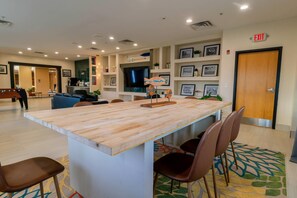 A hotel lobby with a reception desk, seating area, and a wall with framed pictures. - Gateway Hotel & Suites Ocean City, an Ascend Collection Hotel (Ocean City)