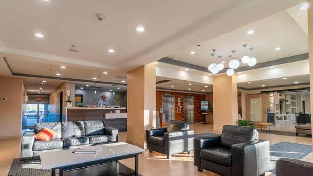 A spacious living area with leather sofas, a coffee table, and a reception desk in the background. - Gateway Hotel & Suites Ocean City, an Ascend Collection Hotel (Ocean City)