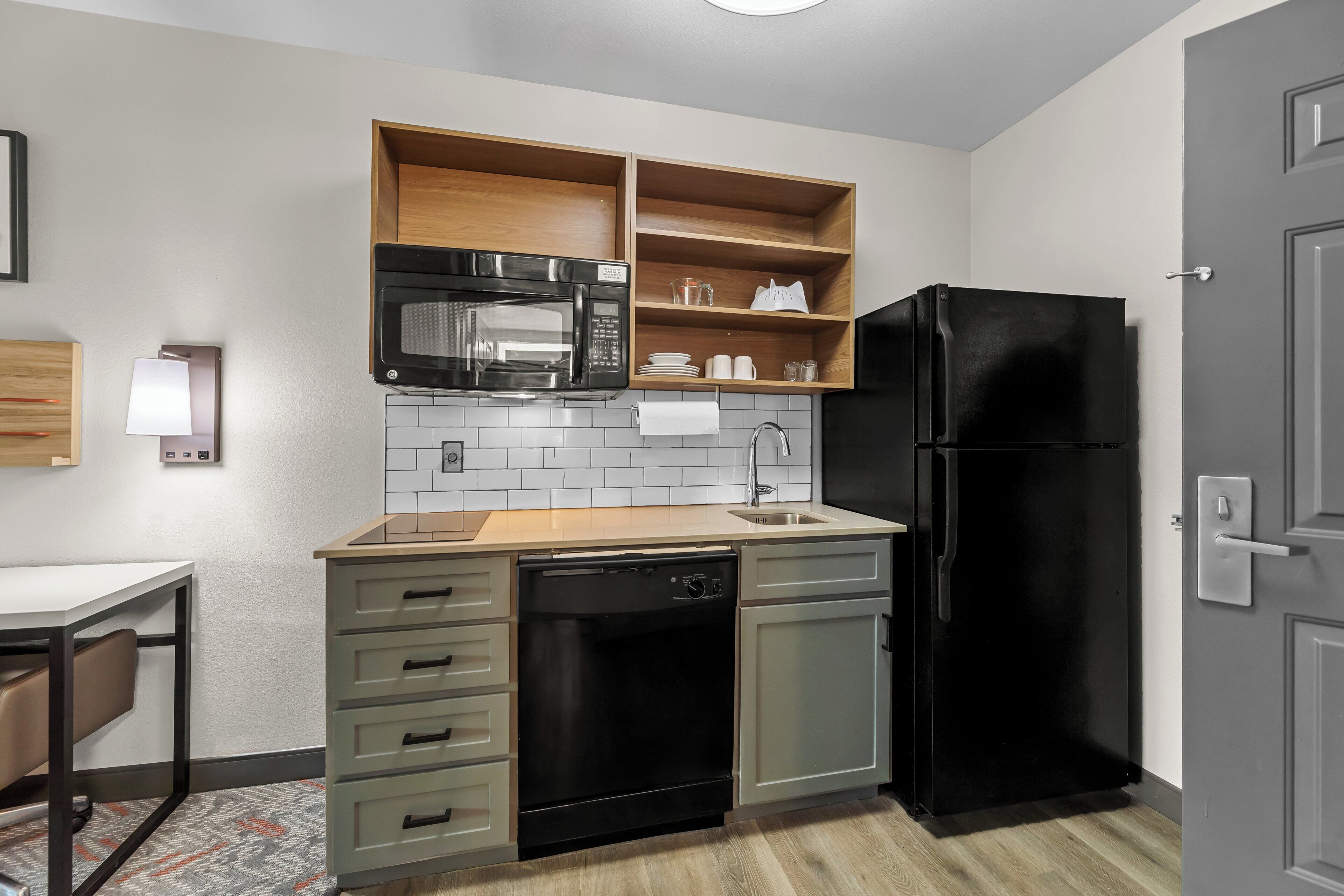 A compact kitchen with a microwave, refrigerator, and dishwasher.