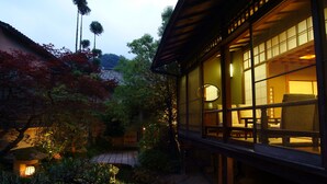 Un edificio de estilo japonés tradicional con ventanas amplias y un jardín con estanque.