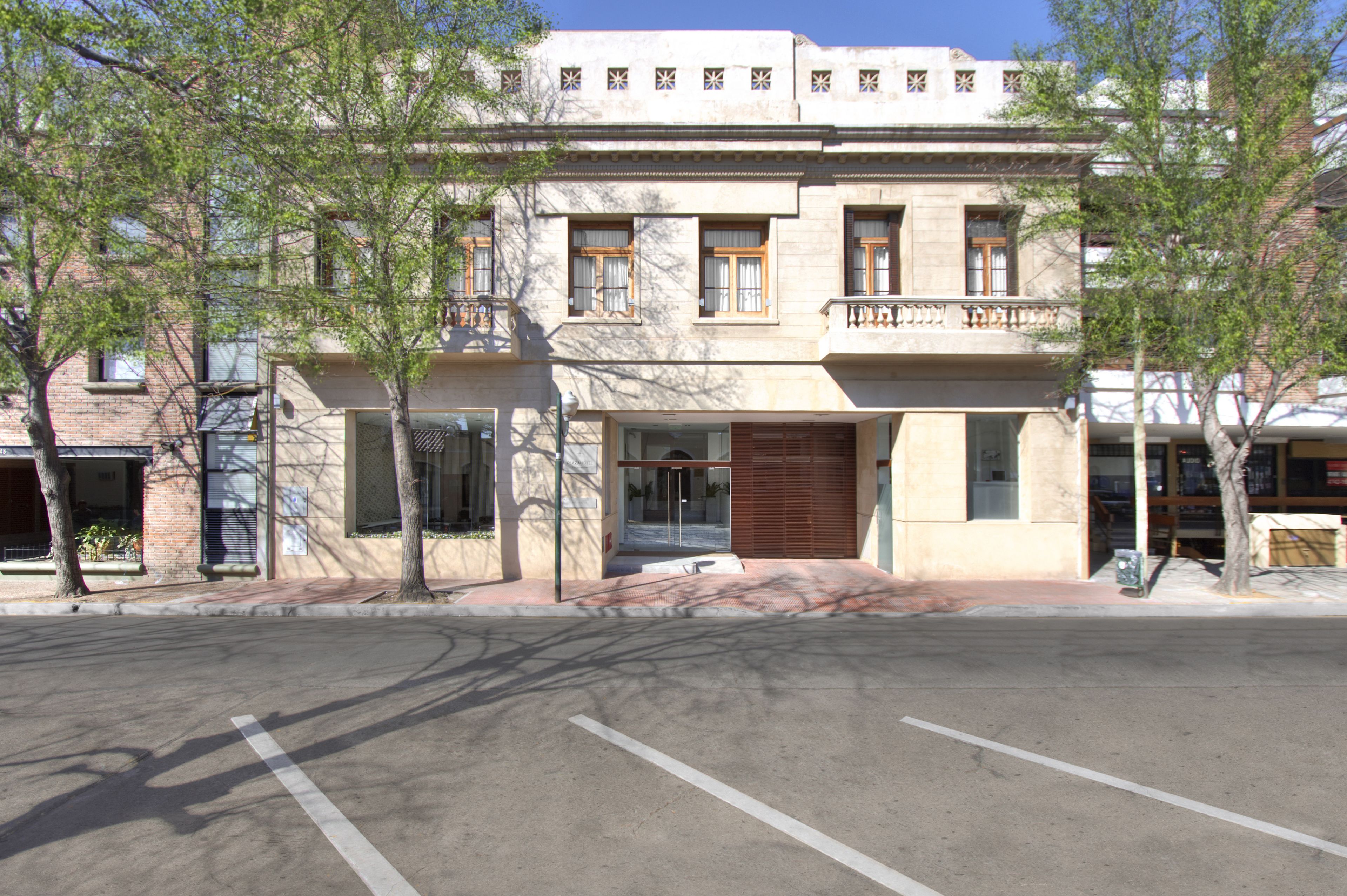 Un edificio de dos pisos con fachada plana, ventanas amplias y una entrada central con puerta de cristal.