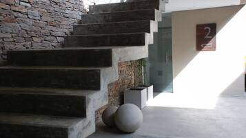 Una escalera con un muro de piedra a un lado y un letrero que indica la habitación número 2.
