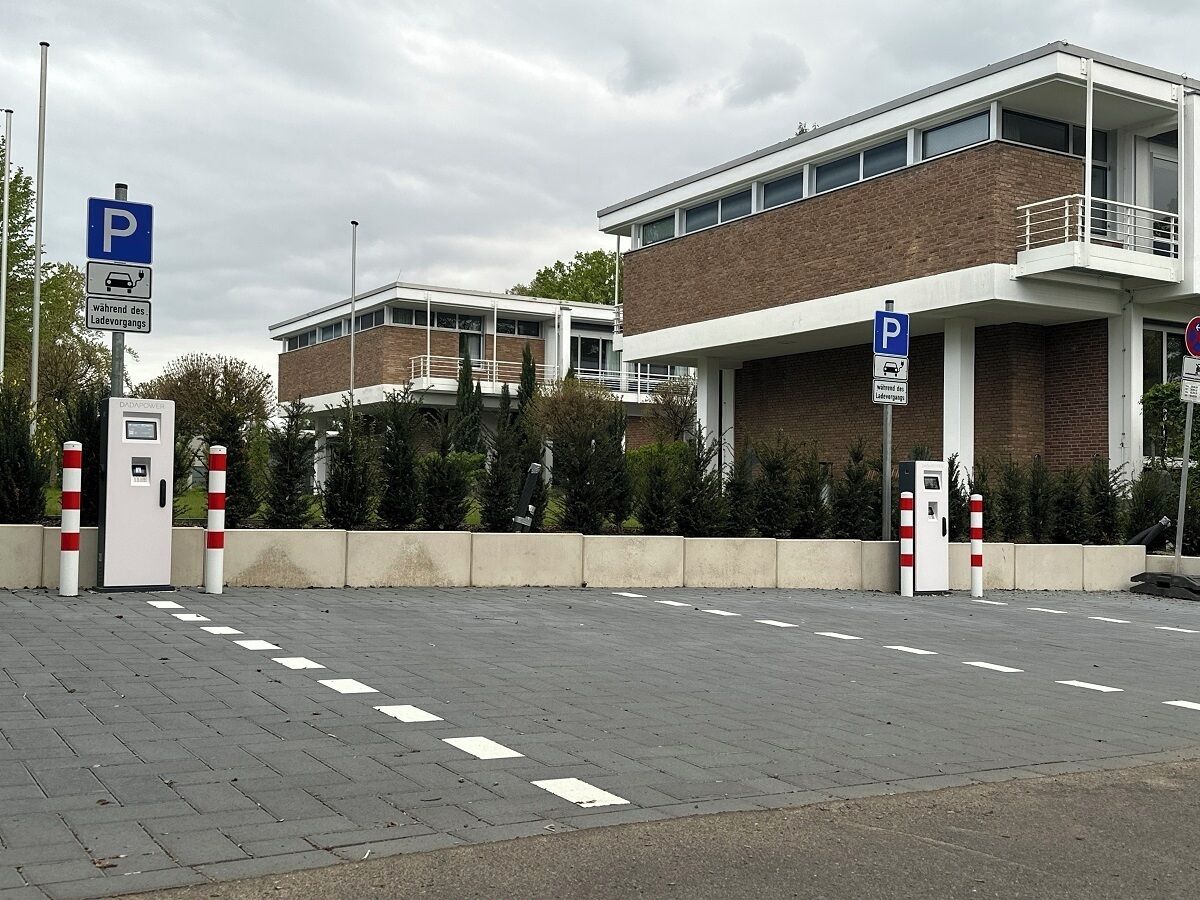 Ein Parkplatz mit einem Gebäude im Hintergrund.
