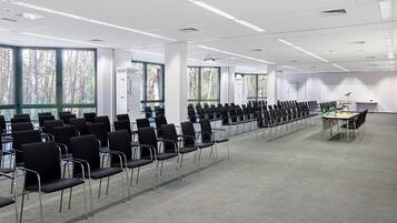 A conference room with rows of chairs, a projector, and air purifiers.
