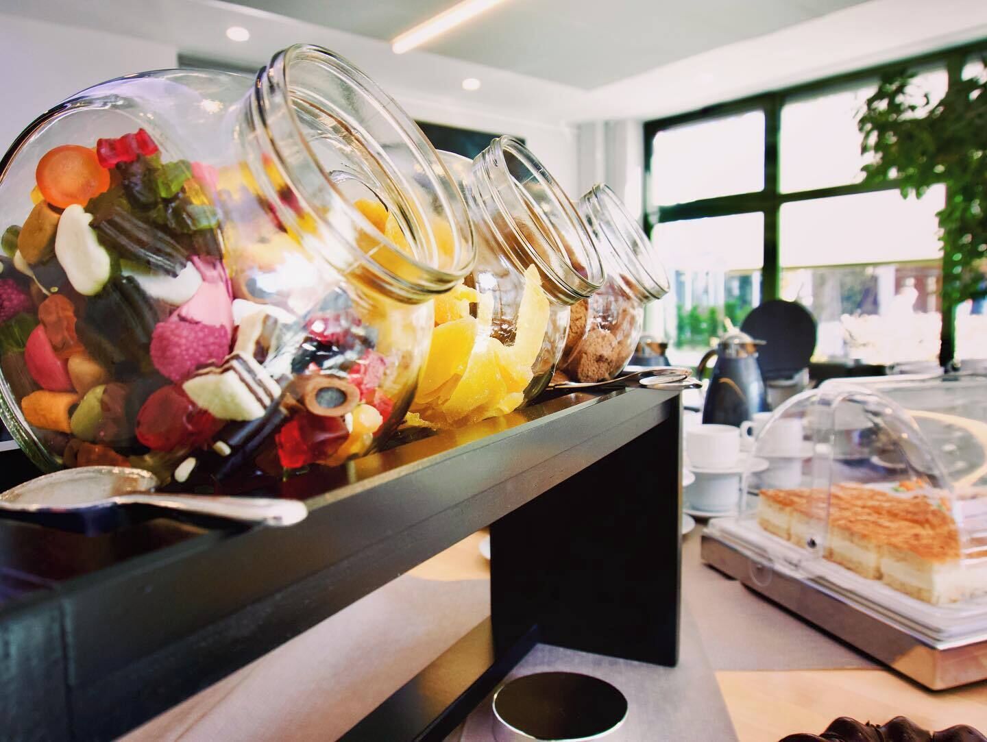 A buffet with various food items in glass containers.