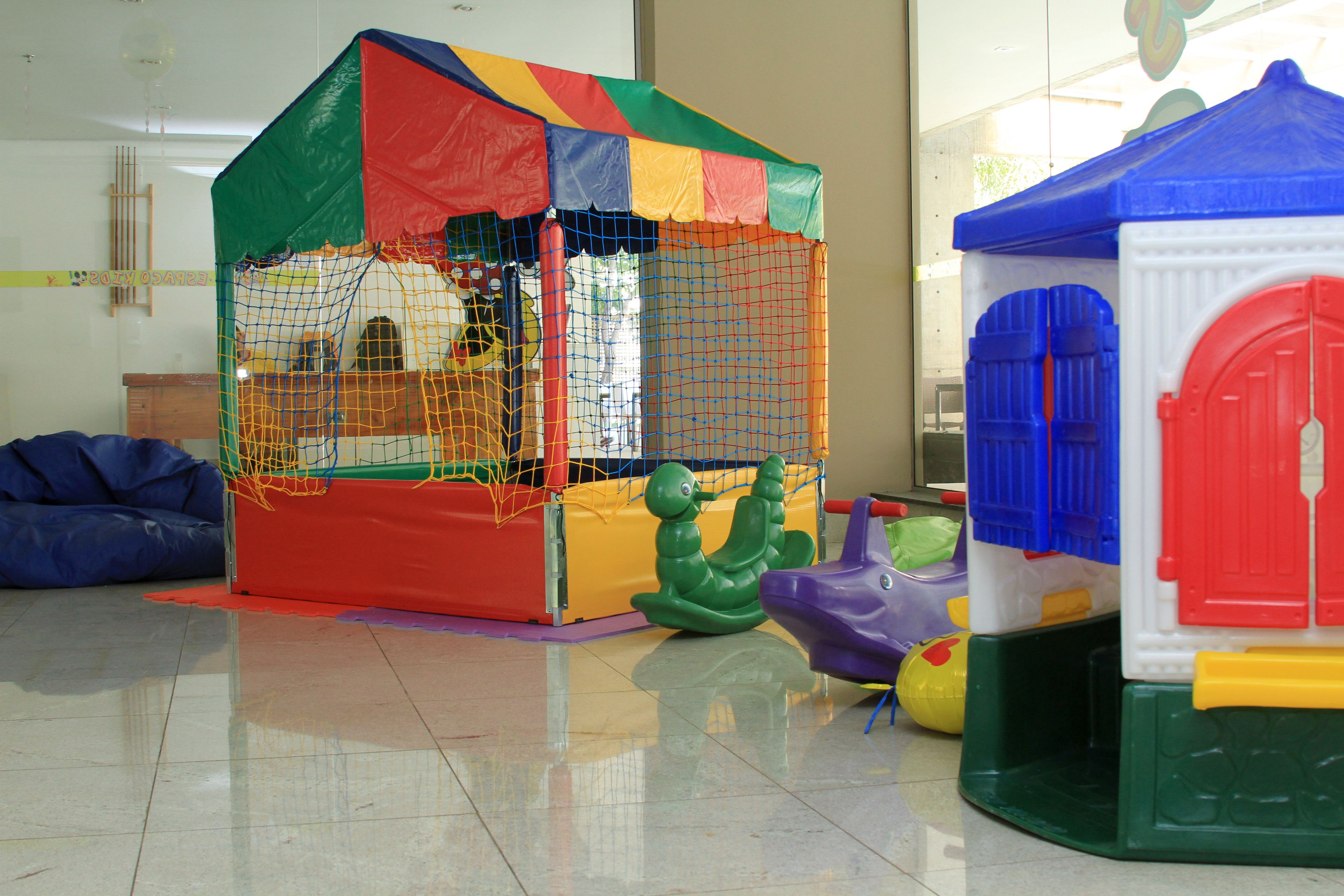 A play area with a colorful playhouse and a netted enclosure.