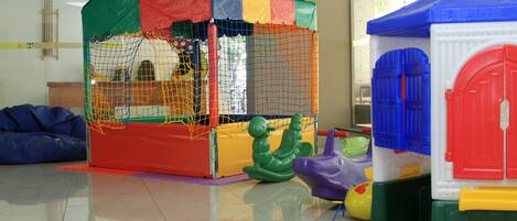 A play area with a colorful playhouse and a netted enclosure.