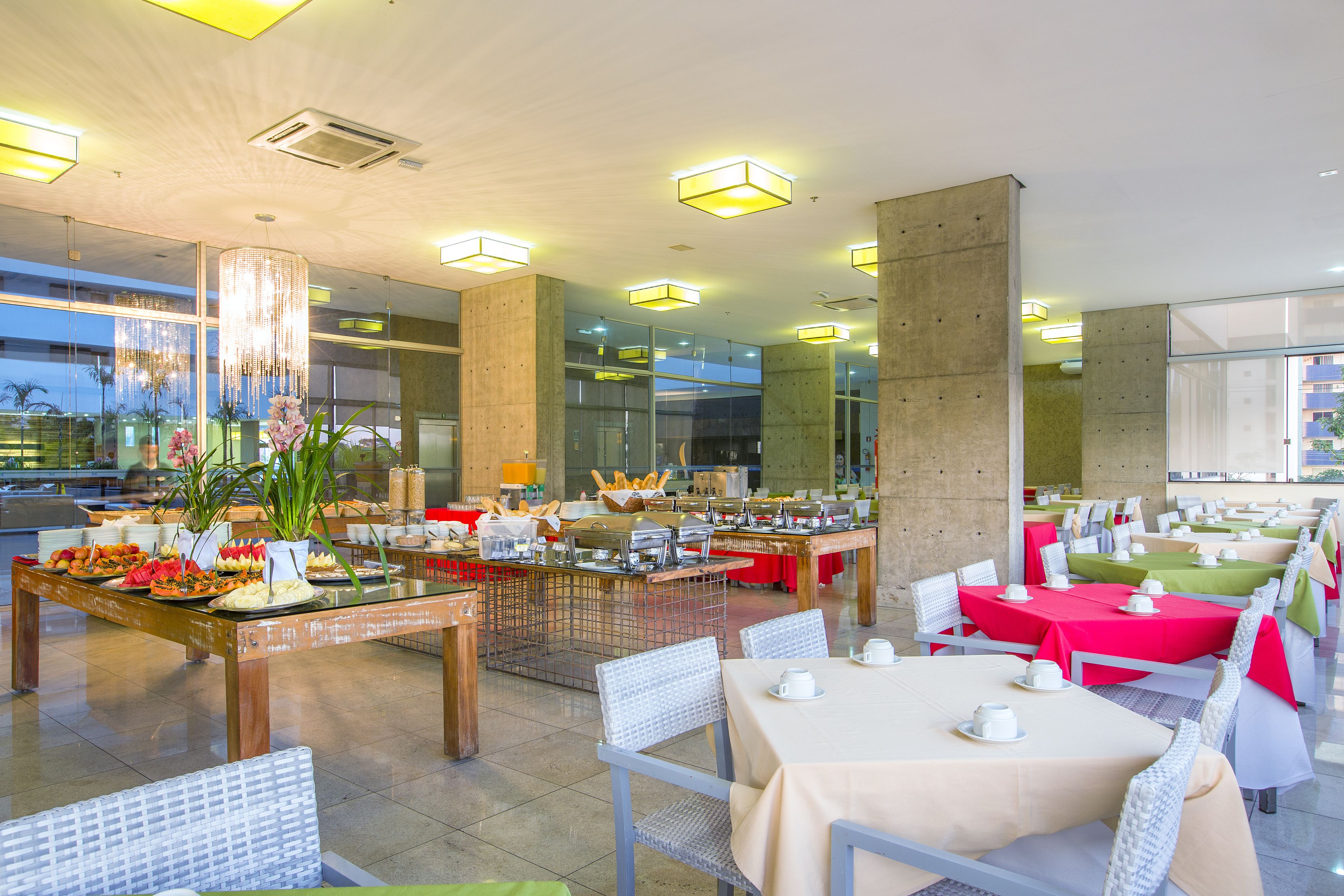 Ein geräumiger Essbereich mit mehreren Tischen und Stühlen, einem Buffet und einem modernen Interieur.