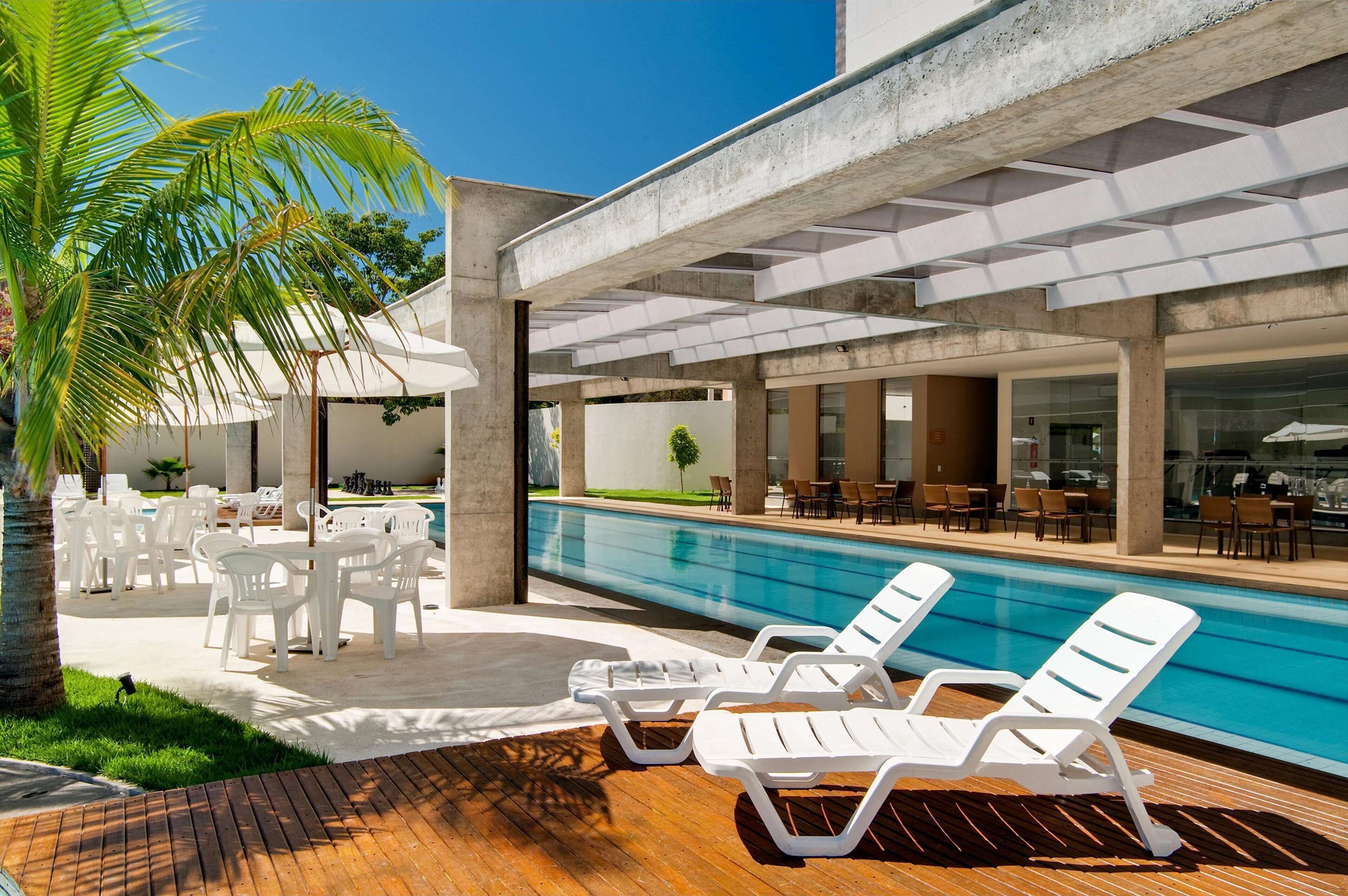 A poolside area with lounge chairs, a pool, and outdoor seating.