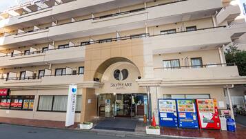A multi-story hotel with a prominent entrance, vending machines, and a sign reading "SkyHeart Hotel".