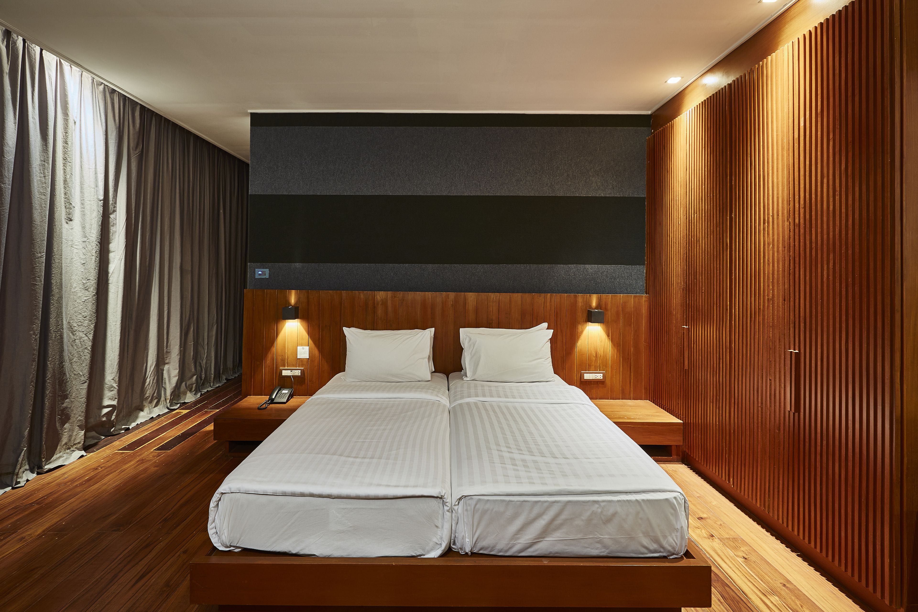 A double bed with a wooden headboard and two bedside tables with lamps.