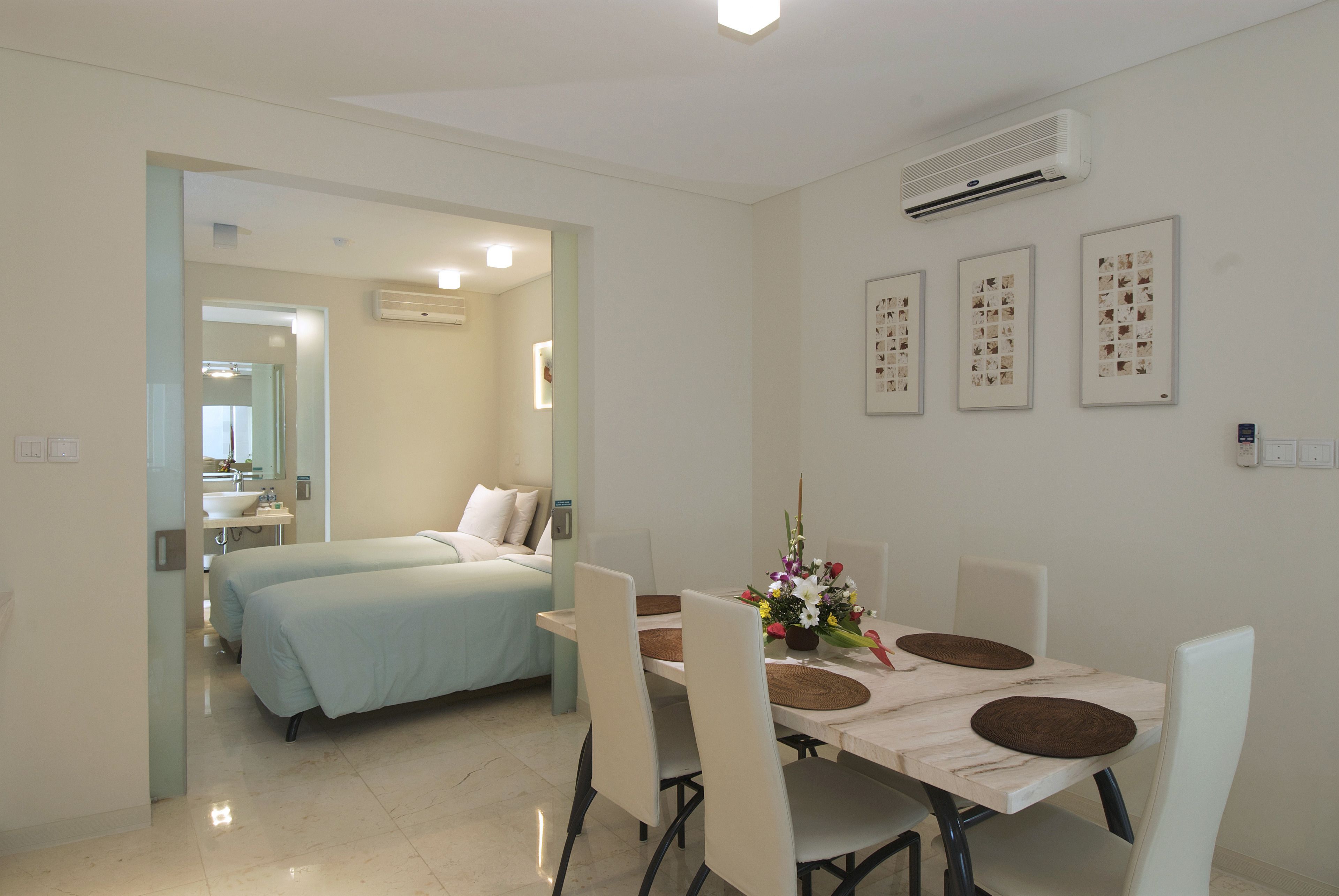 Una camera d'albergo con un letto, un bagno e una zona pranzo con tavolo e sedie.