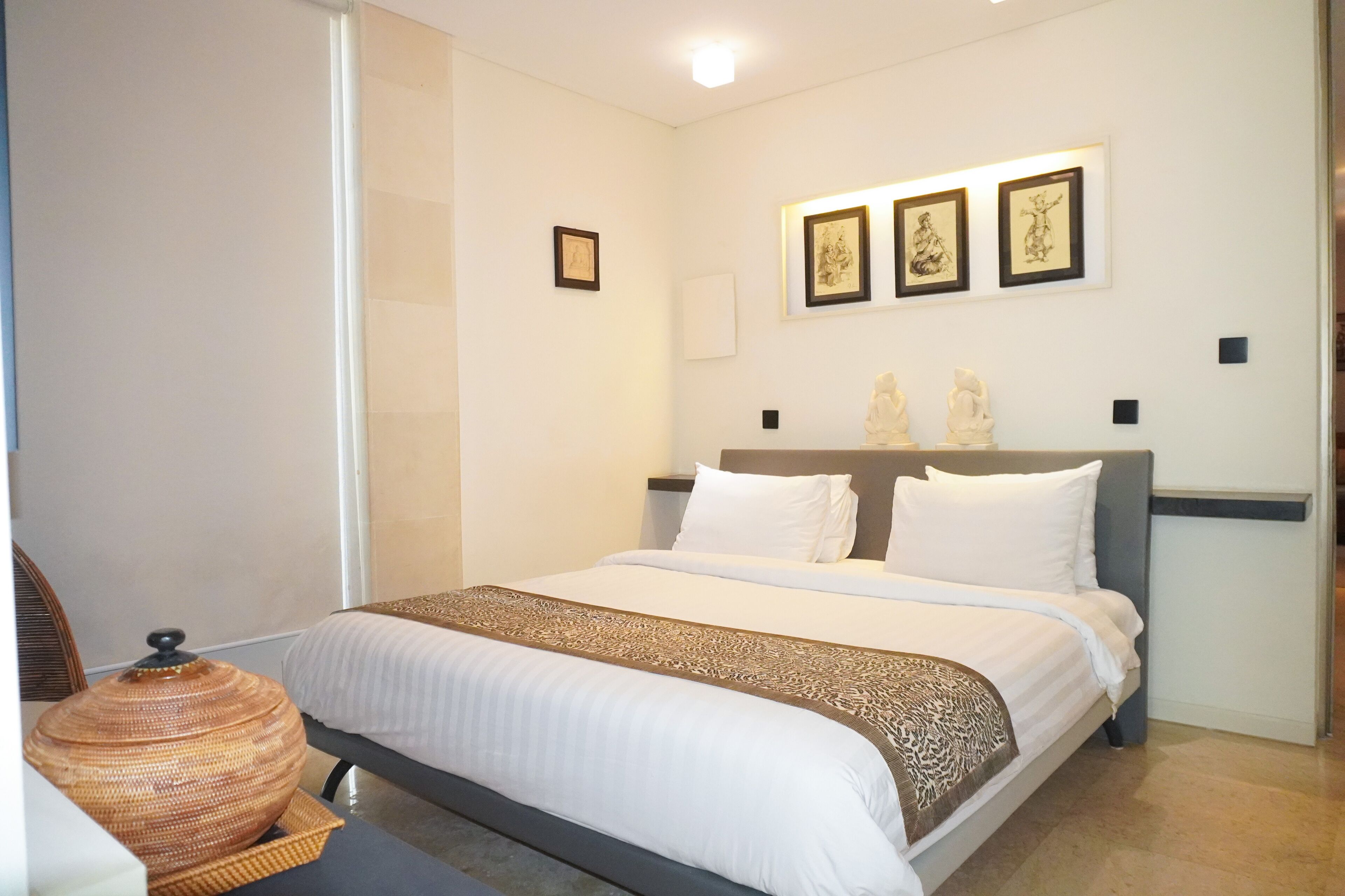 A neatly arranged bedroom with a bed, a bedside table, and a decorative vase.