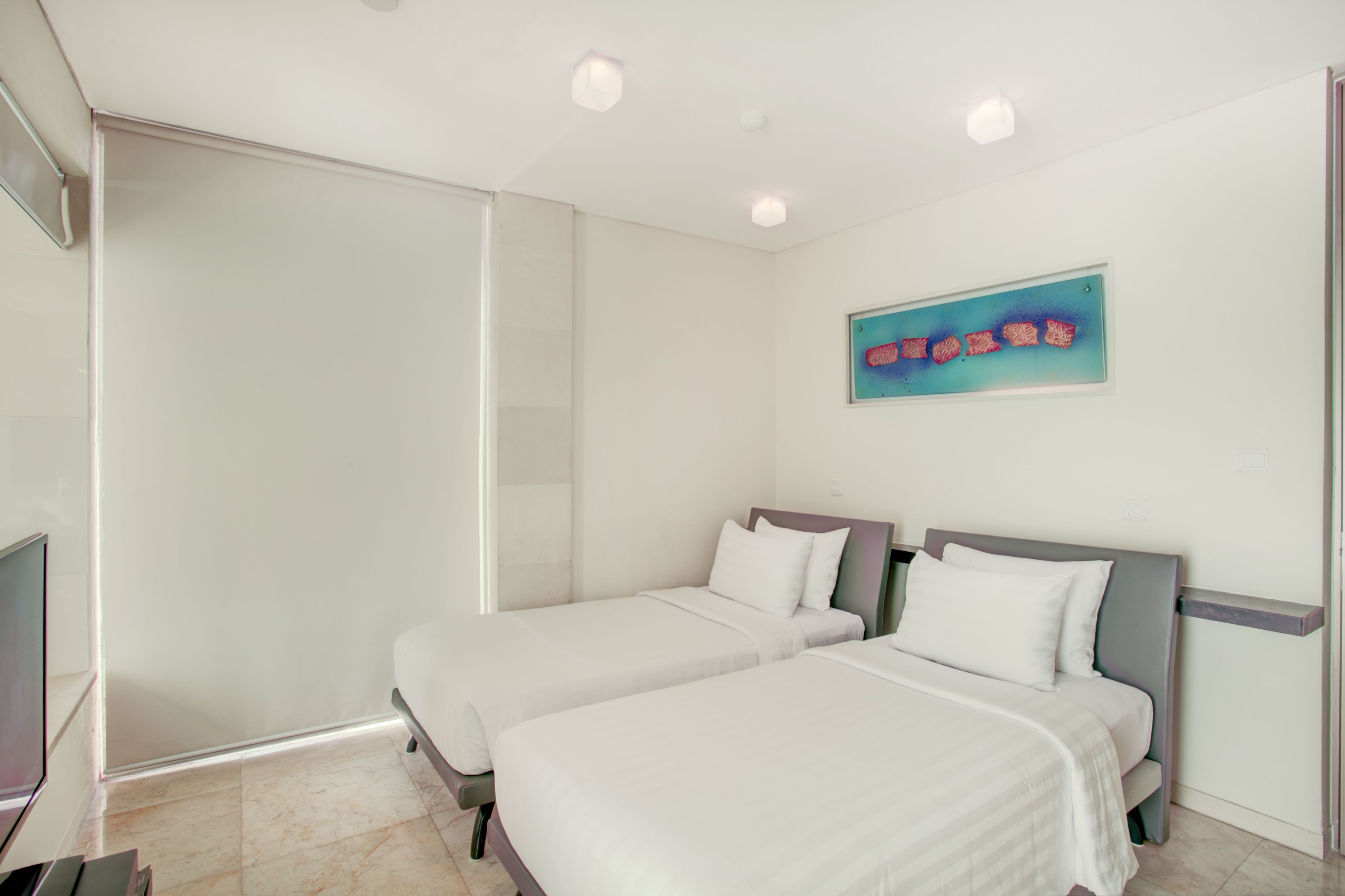 Une chambre d’hôtel avec deux lits, une télévision et une douche en cabine de verre.