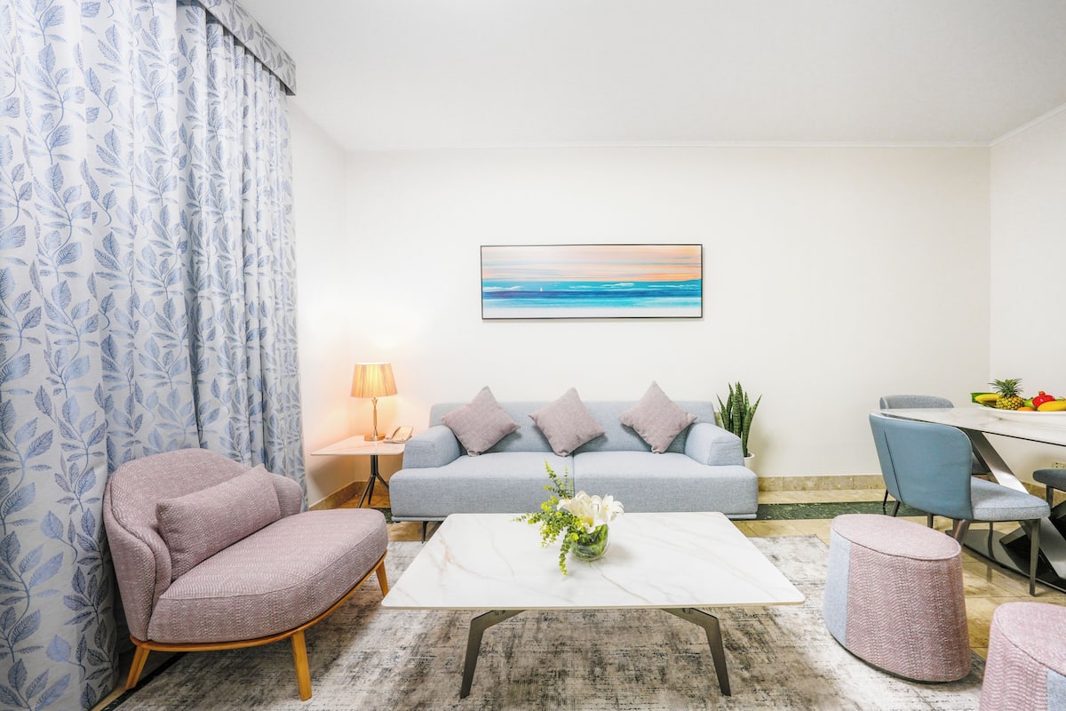 Un salon moderne comprenant un canapé, un fauteuil, une table basse et un coin repas.