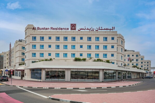 Un hôtel à plusieurs étages, doté d’une entrée imposante et d’une enseigne en arabe.