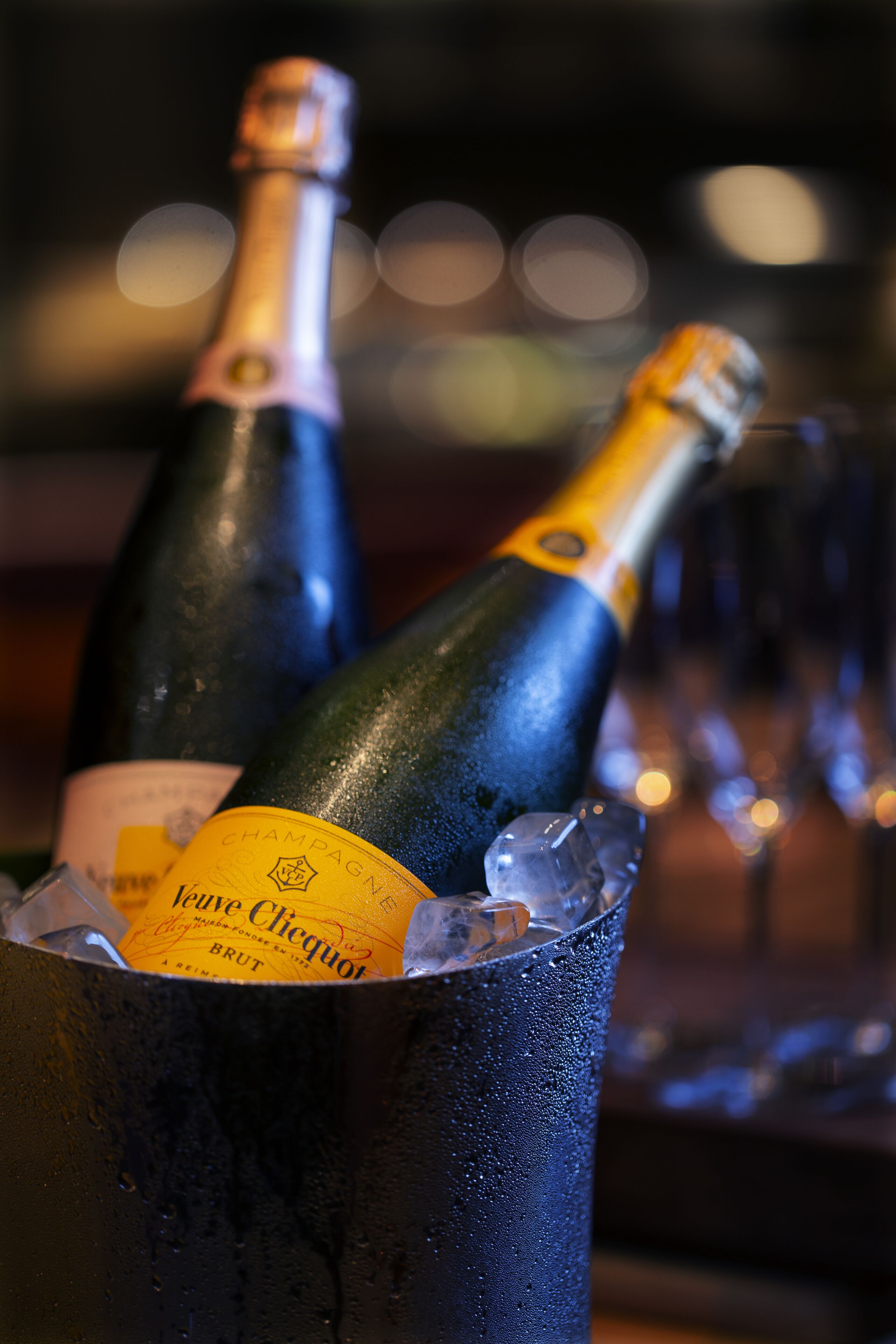 Two champagne bottles in an ice bucket.