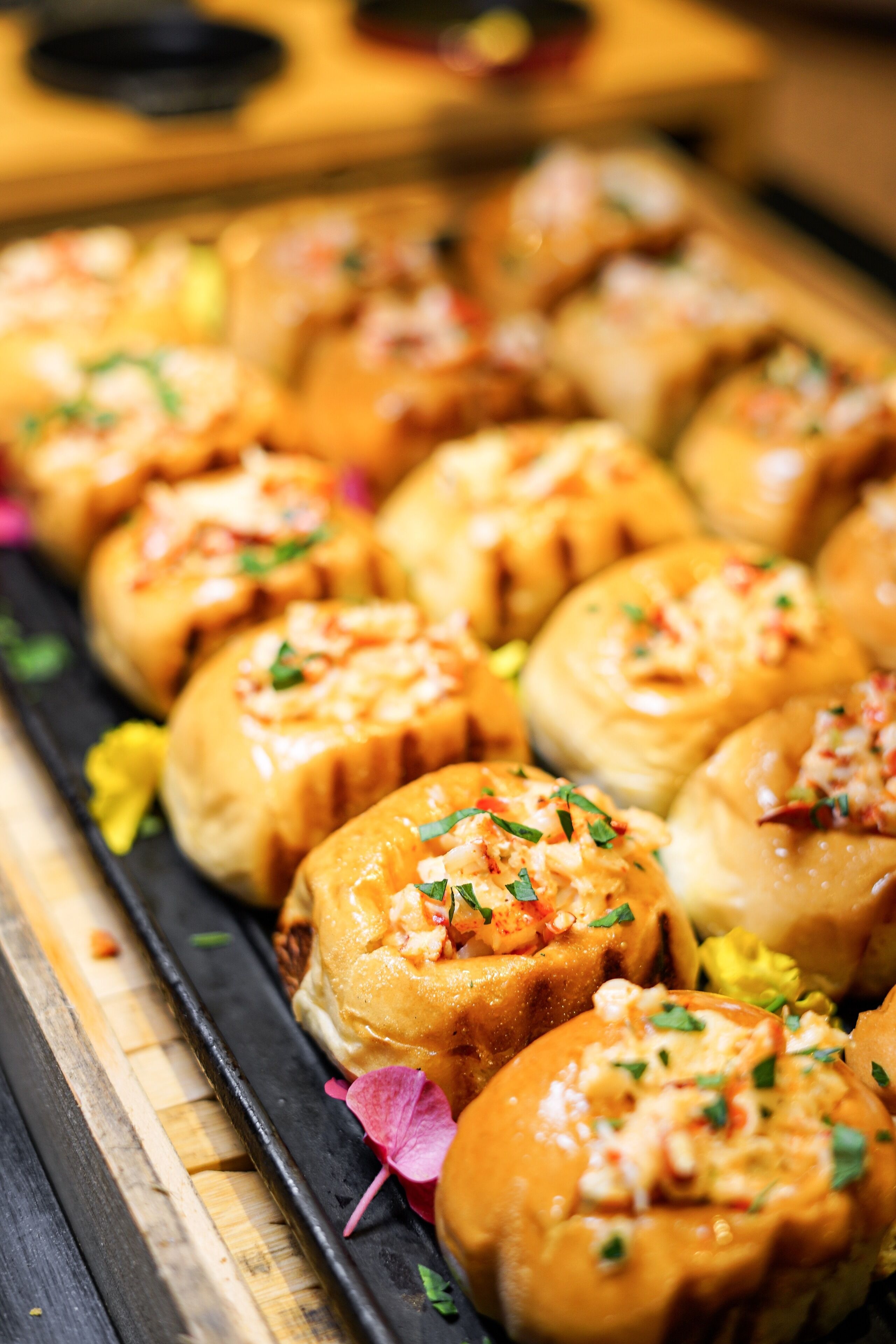 A tray of food items, likely dumplings, arranged on a wooden surface.