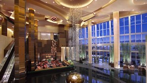 A spacious lobby with a central fountain, seating areas, and large windows offering views. - Grand Hyatt Macau (Cotai)