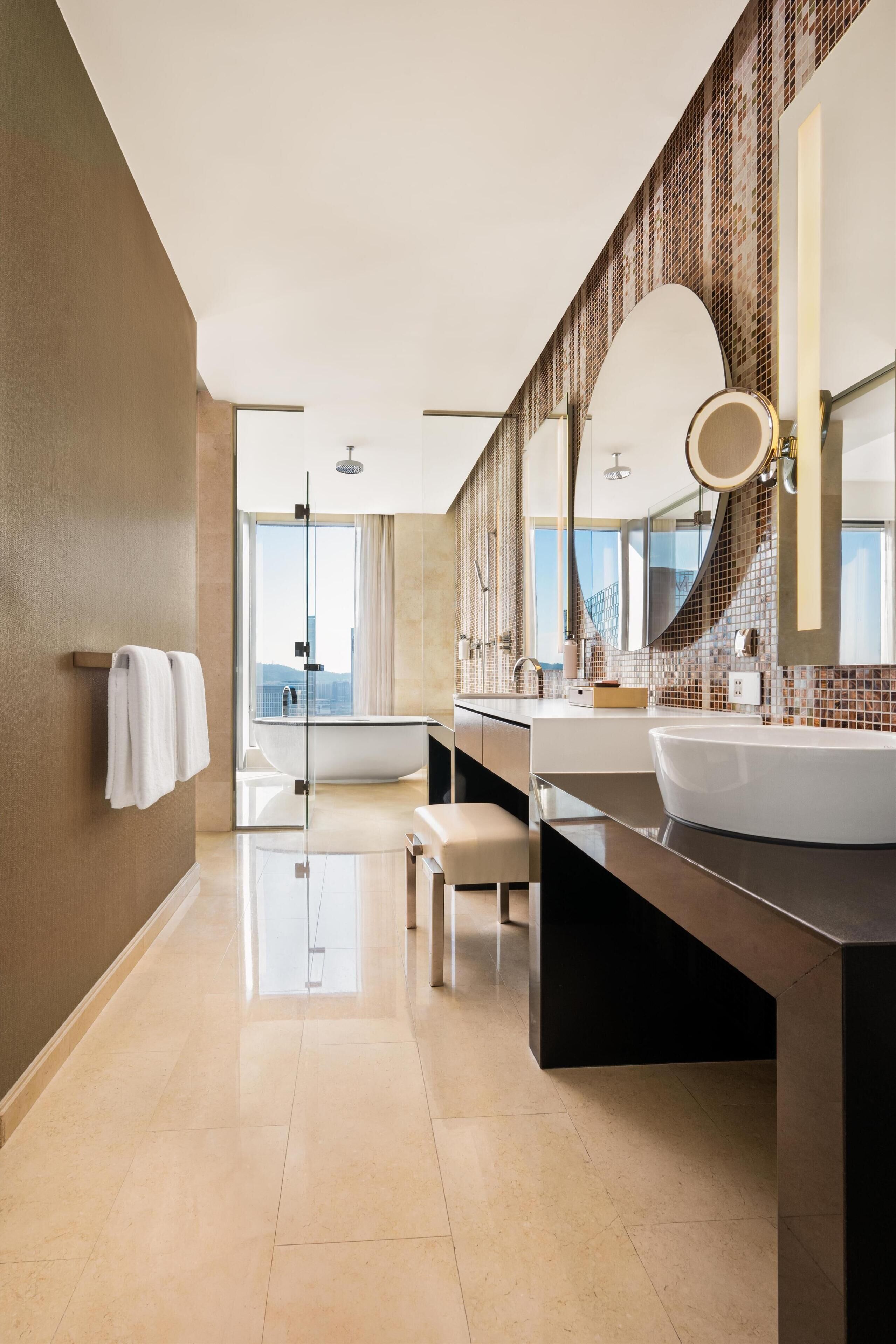 Une salle de bain moderne avec une grande baignoire, un double vasque et un grand miroir.
