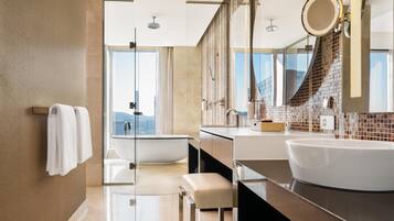 Une salle de bain moderne avec une grande baignoire, un double vasque et un grand miroir.