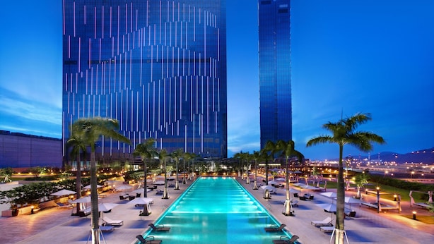 A Grand Hyatt hotel with a pool area, palm trees, and lounge chairs. - Grand Hyatt Macau (Cotai)