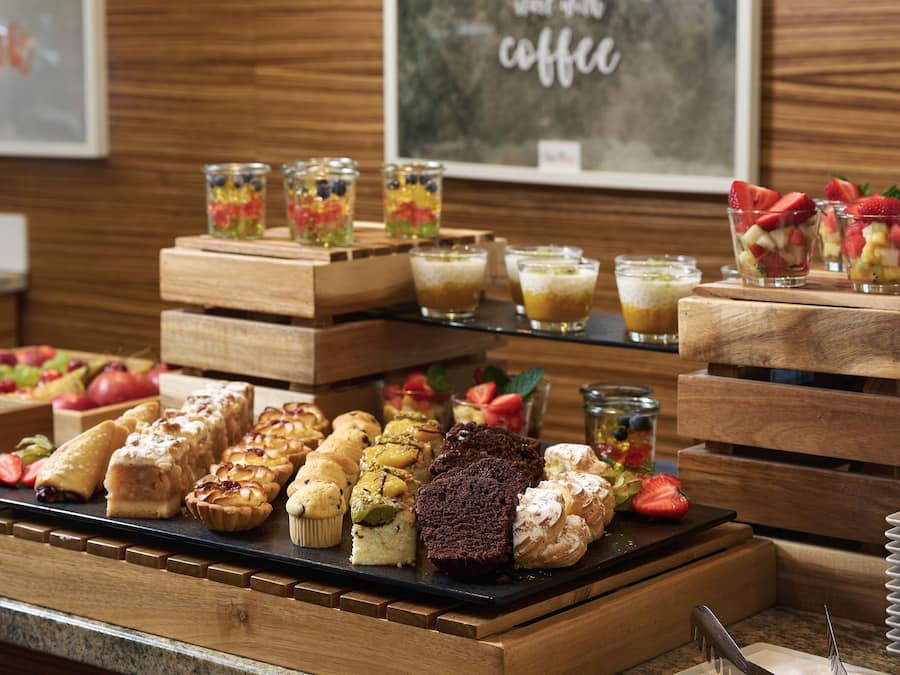 A variety of pastries and desserts displayed on wooden stands.