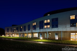 A modern building with multiple windows and a well-lit entrance.