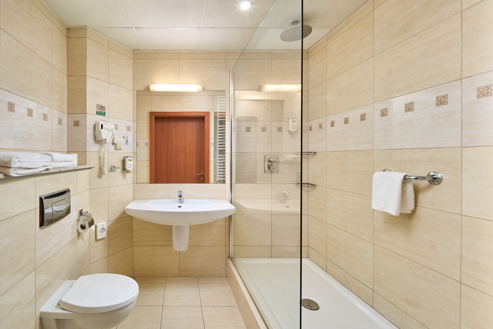 Un baño moderno con lavamanos, inodoro y zona de ducha.