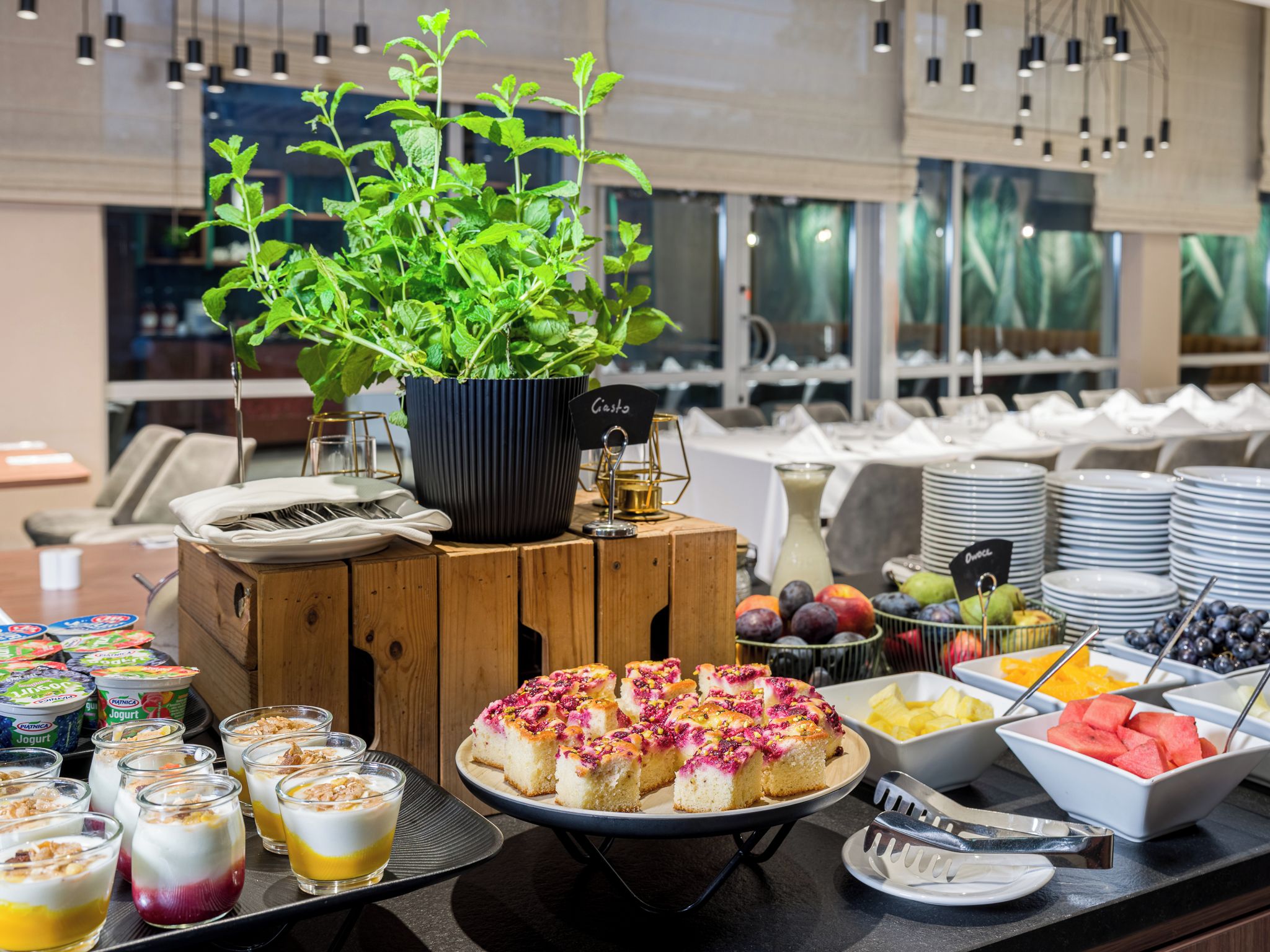 A buffet setup with various food items, a potted plant, and a sign labeled 'Casta'.