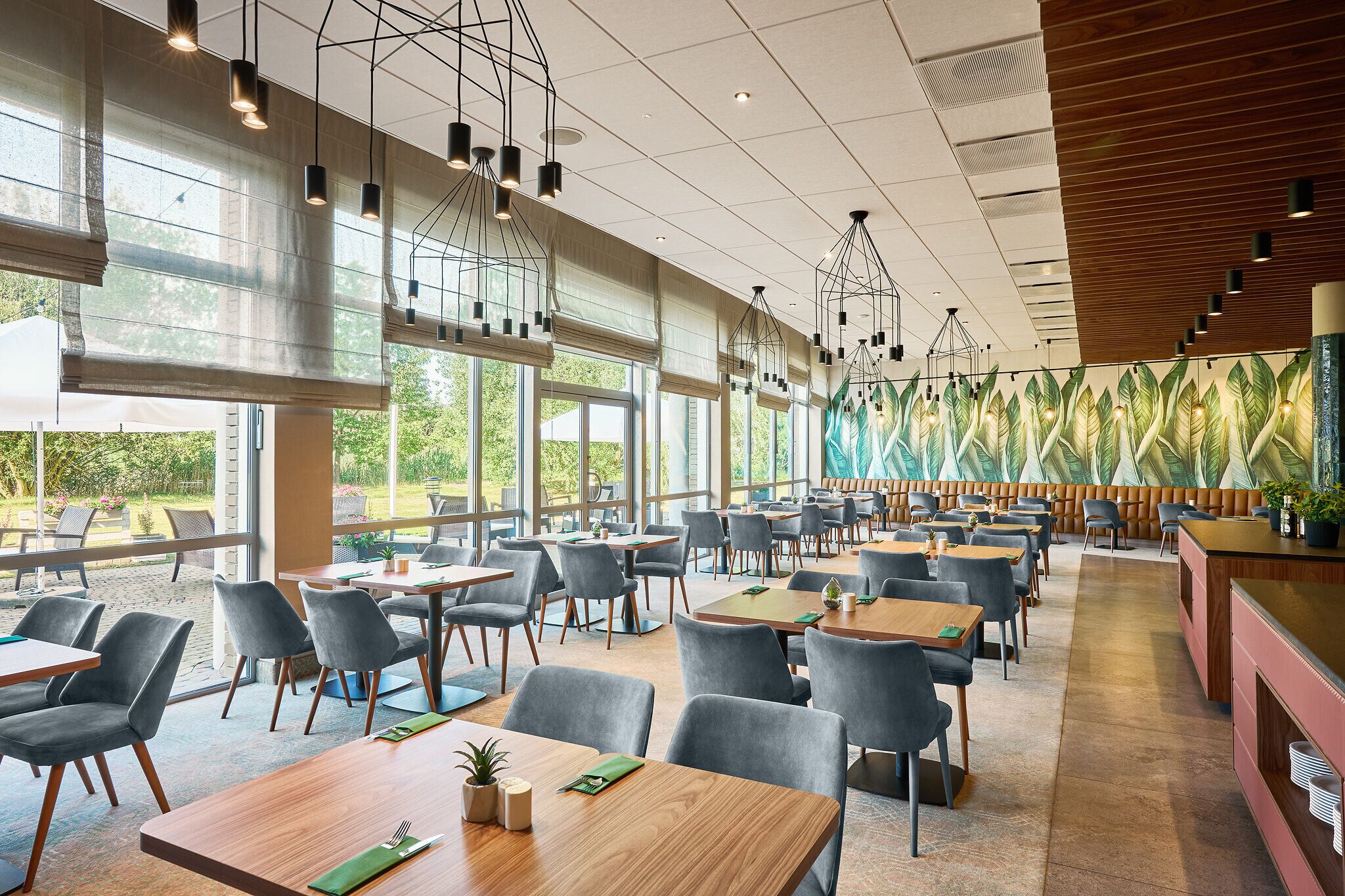 A spacious restaurant with high ceilings, large windows, and modern lighting fixtures.