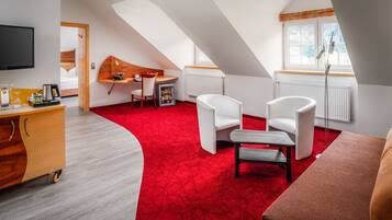A modern room with a red carpet, white furniture, and a TV mounted on the wall.