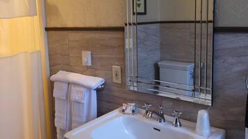 A bathroom with a white sink, a mirror, and a shower curtain.
