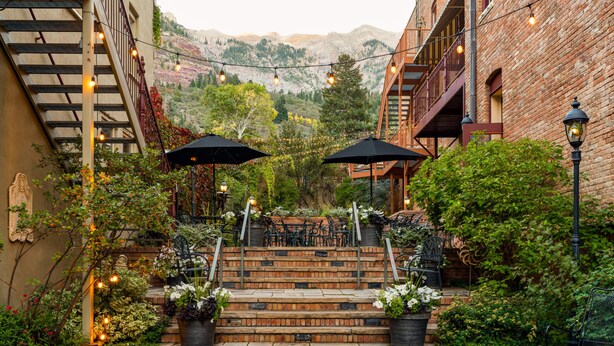 A courtyard with brick steps, outdoor seating, and string lights. - Beaumont Hotel & Spa - Adults Only (Ouray)