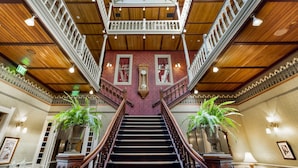 A grand staircase with a glass ceiling, flanked by ornate railings and potted plants. - Beaumont Hotel & Spa - Adults Only (Ouray)