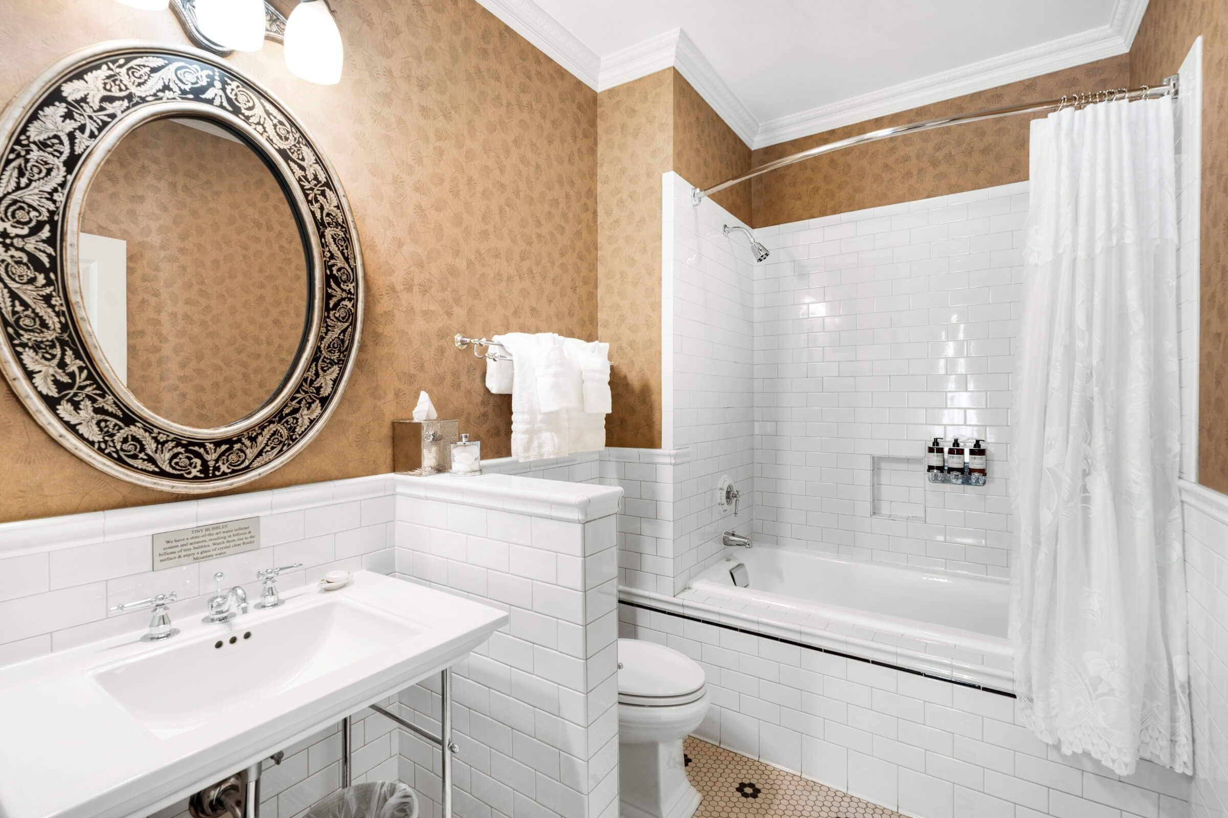 A bathroom with a white sink, mirror, and bathtub.