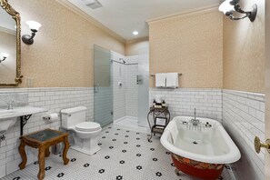A bathroom with a white toilet, a sink, a shower, and a red bathtub. - Beaumont Hotel & Spa - Adults Only (Ouray)